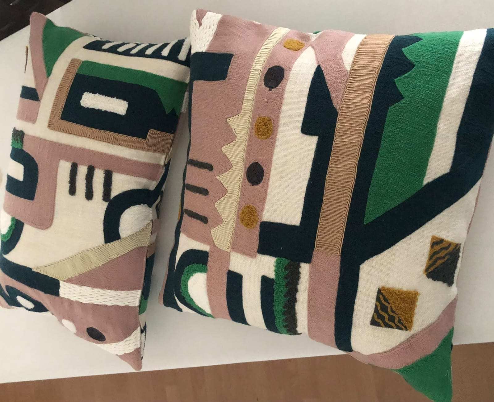 Two cushions in the same embroidered fabric
