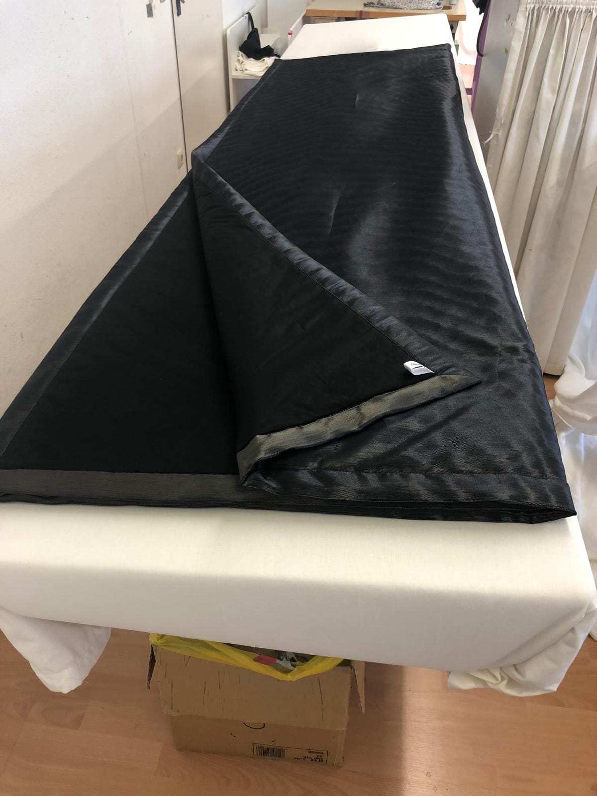 Dunkler Vorhang mit Futter auf dem Zuschnitttisch