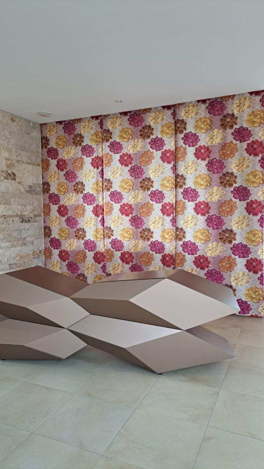 Fertig aufgehängte Vorhänge aus großgemustertem Blumenstoff, über die ganze Wand